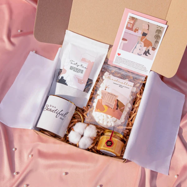 Petite gift box with soaps, a soy candle and a wrapped treat tied with ribbon